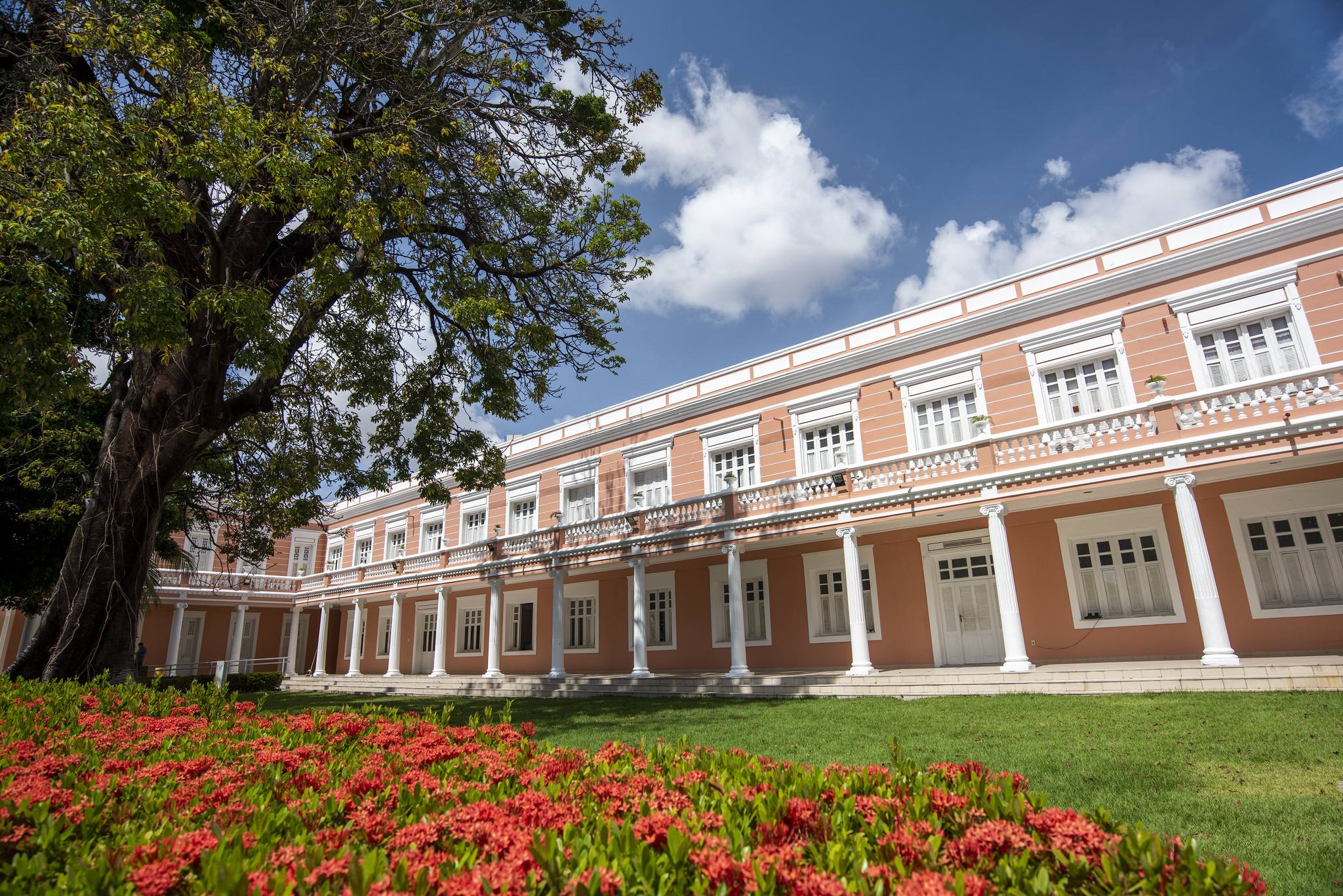 Pr&eacute;dio hist&oacute;rico da Reitoria, edifica&ccedil;&atilde;o cor de rosa com branco, em volta de jardins